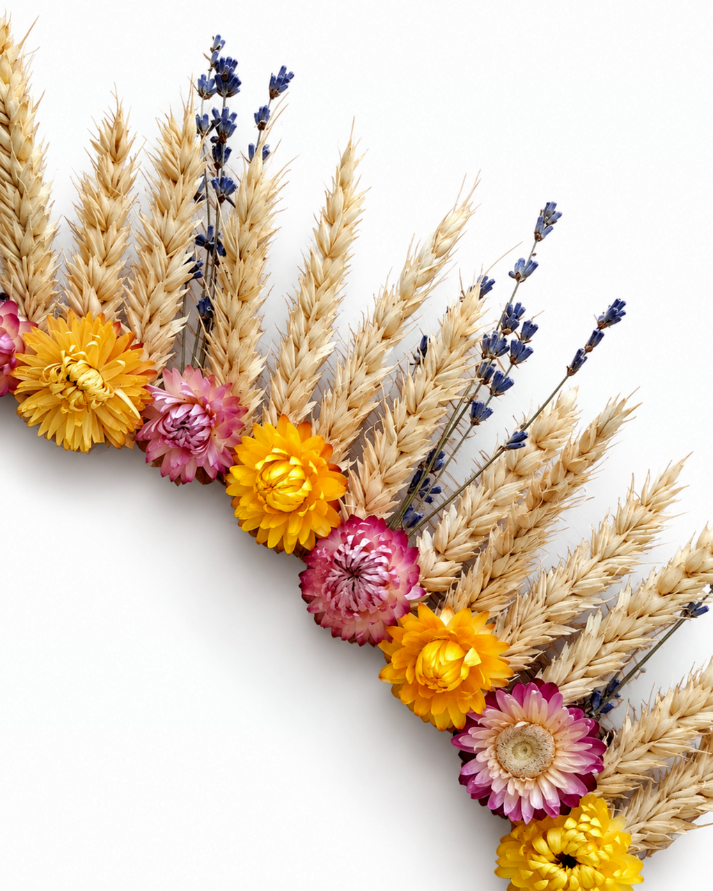 Close-up shot showing details of golden wheat ears, lavender, and pink strawflower heads on the wreath.
