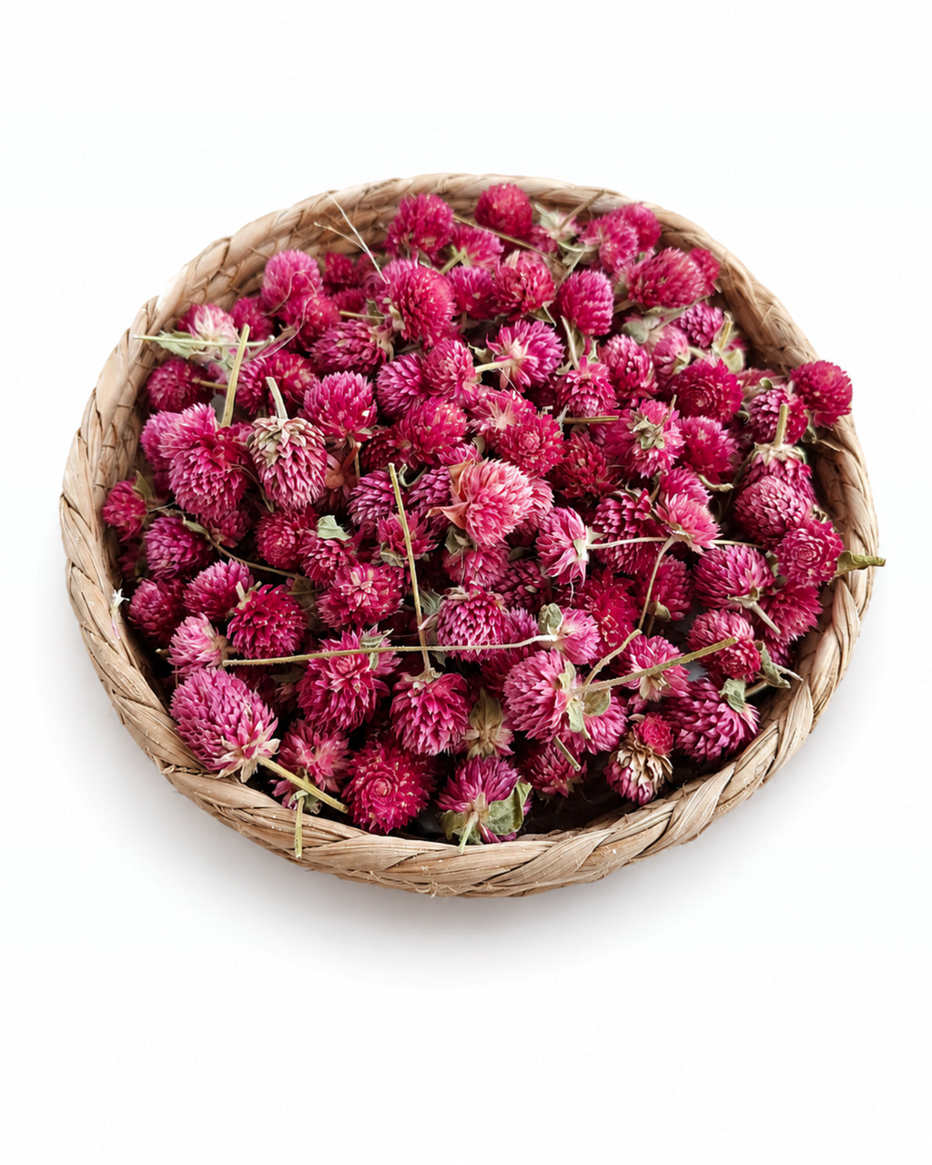Top-down view of a round woven basket filled with magenta dried Gomphrena flower heads.
