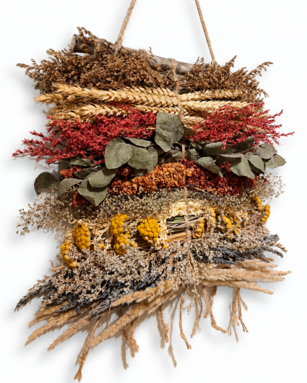 Angled shot showing the layered arrangement of green eucalyptus, wheat, and dried flowers in a wall tapestry.
