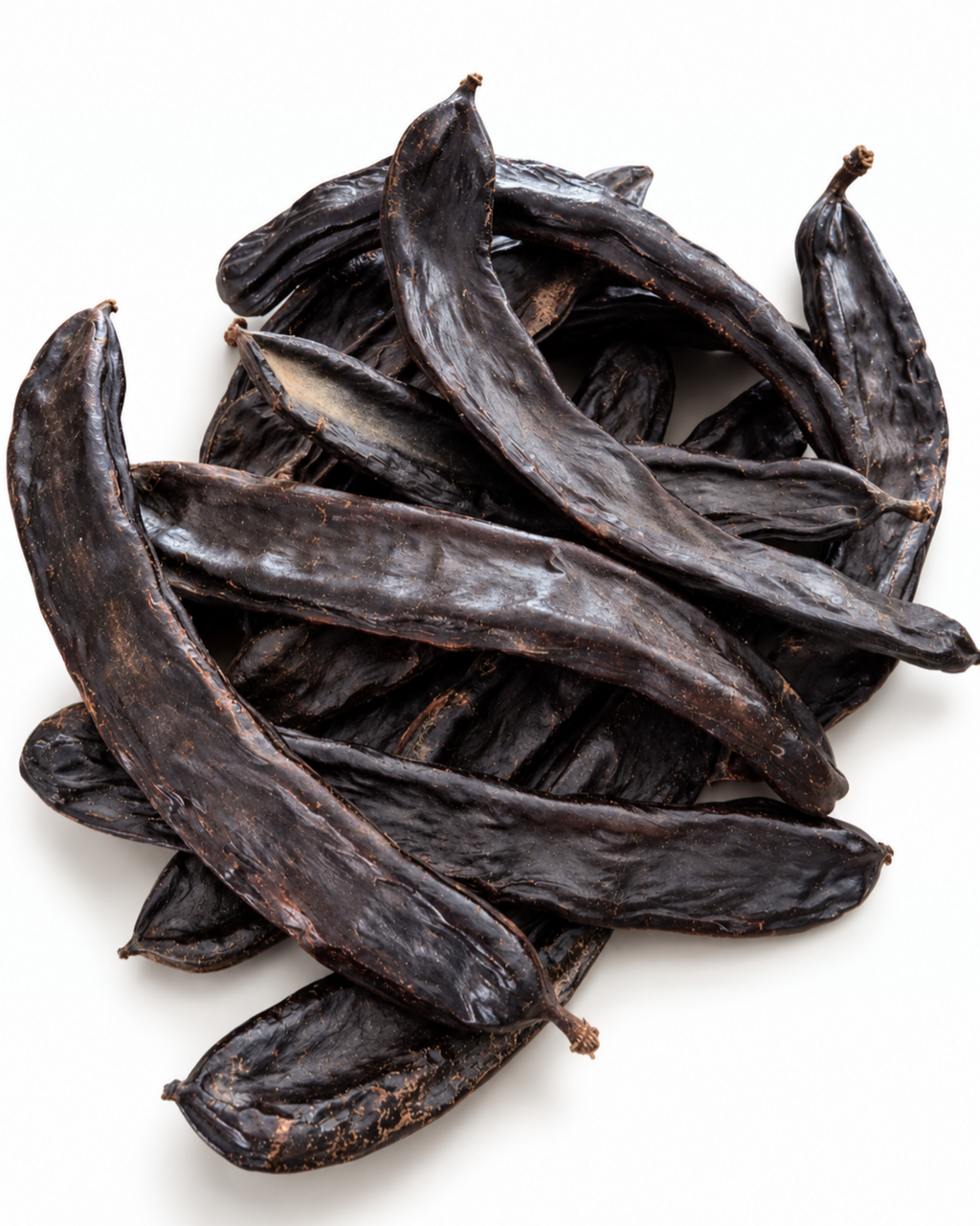 Pile of 10 unprocessed raw dried carob pods on a seamless white background.
