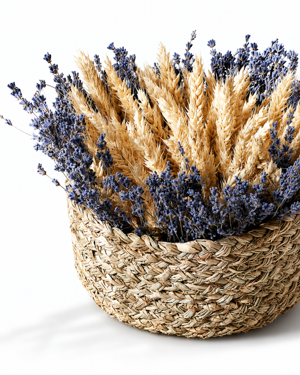 Close-up texture shot of yellow, purple, and ivory dried flowers arranged in a straw basket.
