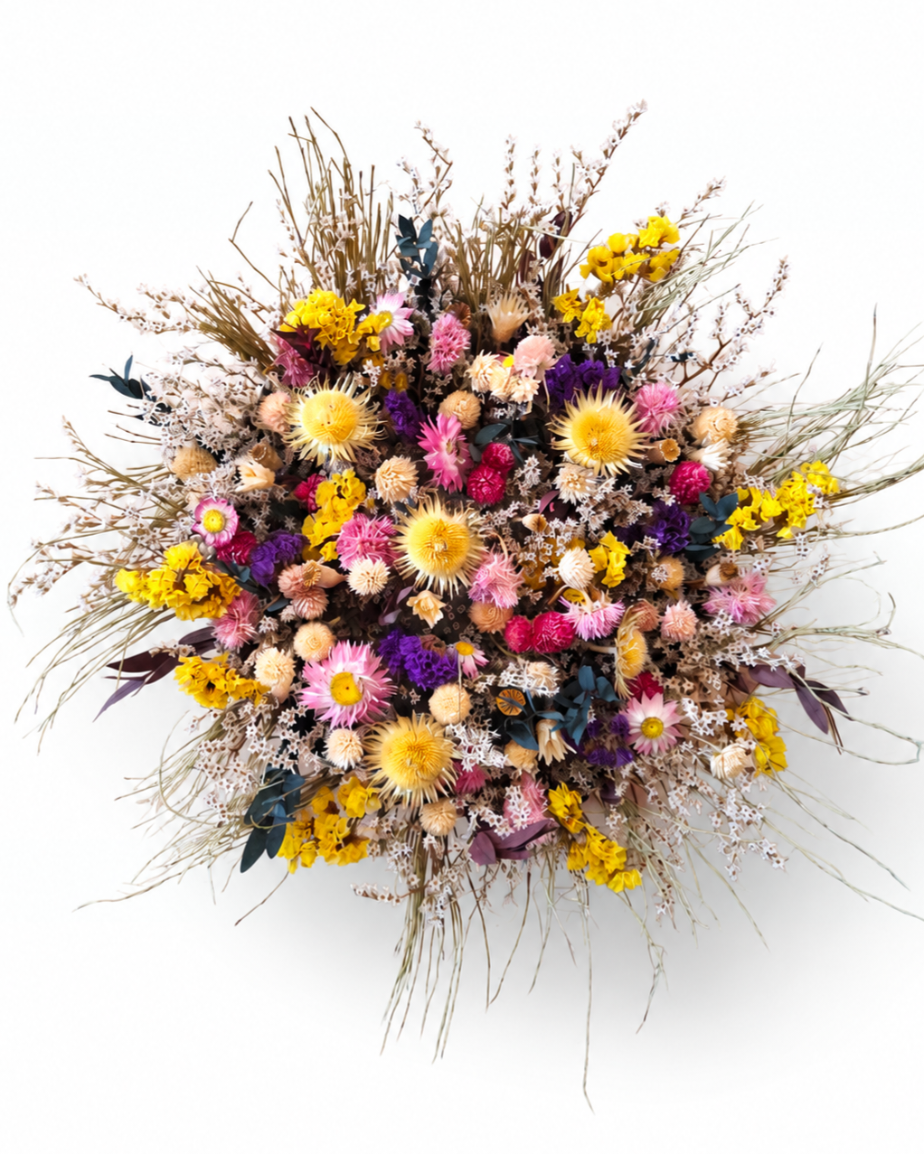A person holding the colorful dried wildflower basket arrangement from above against a white background.
